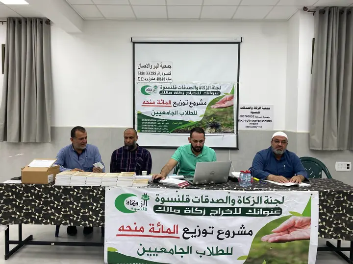 أعضاء اللجنة على طاولة توزيع المنح الجامعية
